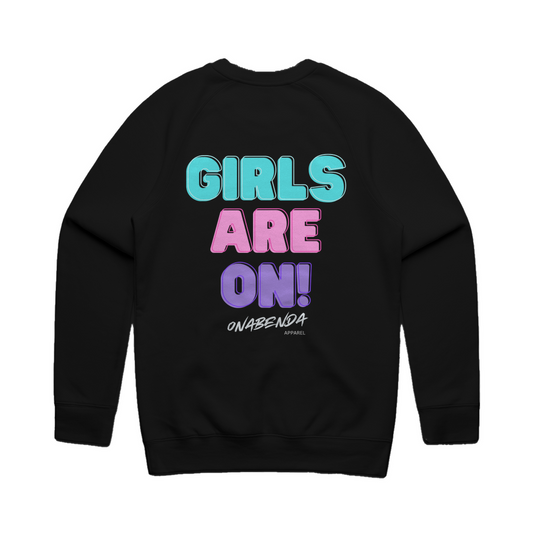 Black crewneck sweatshirt with the text 'GIRLS ARE ON!' in bold capital letters, with 'GIRL' in pink and 'ARE ON' in blue, on the back of the sweatshirt.